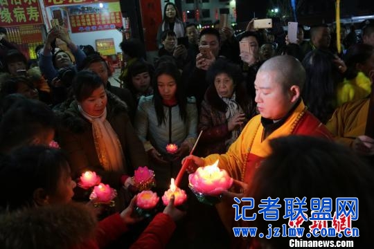 法师为南岳古镇商户、游客点亮莲花灯。 文丽贵 摄