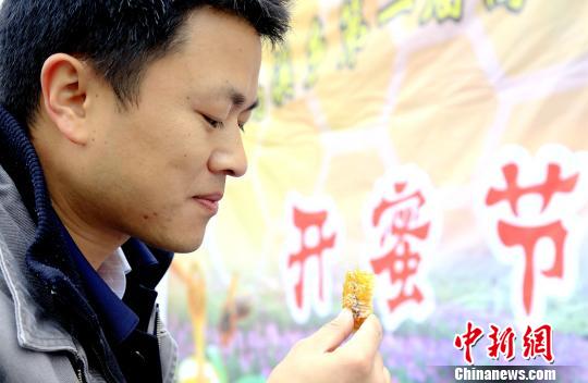 图为民众品尝蜂蜜。 奉力 摄