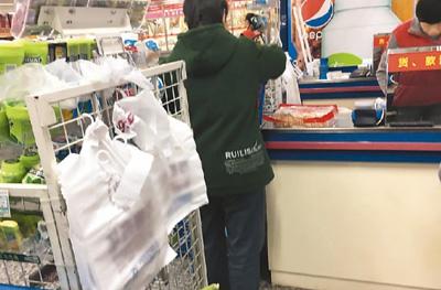 北京市朝阳区金台路一家超市内收银处悬挂的塑料购物袋。　本报记者 彭训文摄