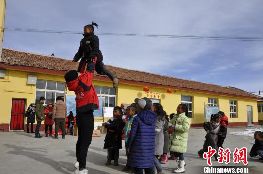 一群孩子排队要求志愿者哥哥“举高高”。 陈茂霖 摄