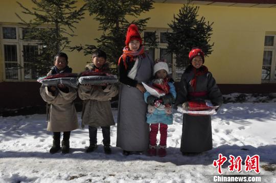 一位老师与四位刚刚领取到爱心物资的孩子合影。 陈茂霖 摄