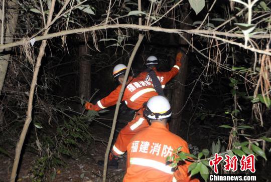 搜救现场，穿行树林。(郑振盛摄)