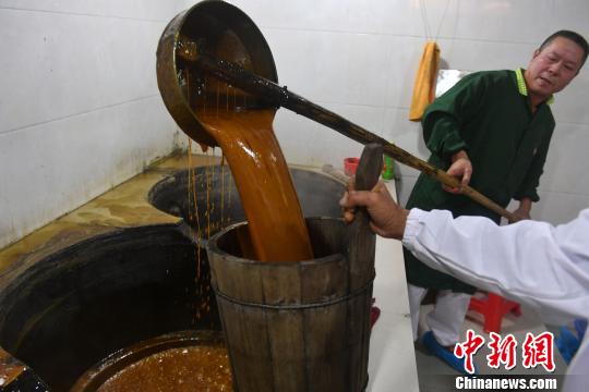熬制完成的红糖水起锅。 吕明 摄
