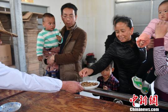 游客与群众竞相品尝。 吕明 摄