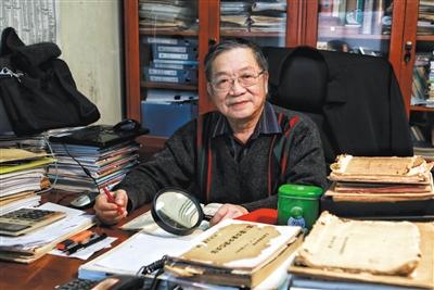 退休后,梁金生的工作相对简单。更多时候,他拿着一柄放大镜,趴在办公桌上“翻旧账”。